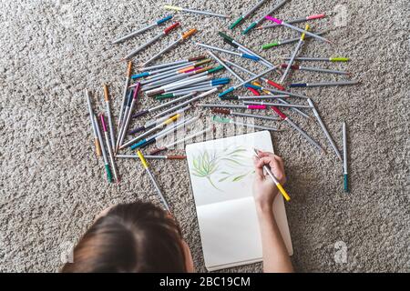 Schnittansicht der Frau auf dem Boden liegend Zeichnung mit farbigem Bleistift in Skizzenbuch Stockfoto