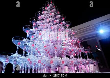 Auf dem Tisch steht ein Turm mit leeren Martini-Gläsern mit Kirsche. Party im Club Phaselis Rose Hotel in Kemer, Türkei, festlicher Abend in Tekirova Stockfoto