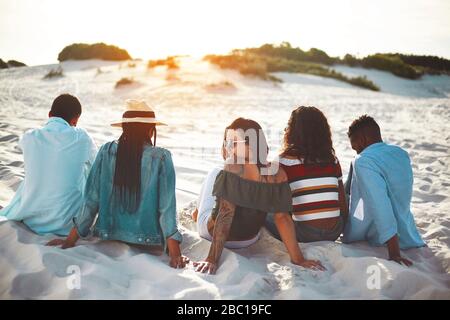Junge Freunde hängen am Strand aus Stockfoto