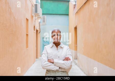 Porträt einer selbstbewussten Frau, die in einer Gasse steht Stockfoto