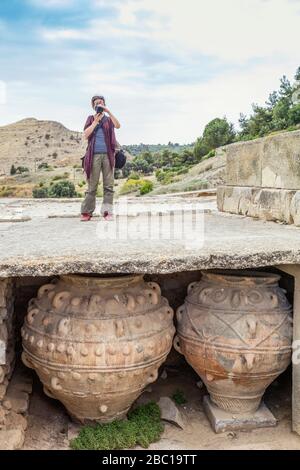Frau, die vor Ort des minoischen Palastes in Phaistos, Kreta, Griechenland fotografiert Stockfoto