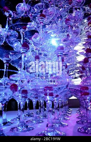 Auf dem Tisch steht ein Turm mit leeren Martini-Gläsern mit Kirsche. Party im Club Phaselis Rose Hotel in Kemer, Türkei, festlicher Abend in Tekirova Stockfoto