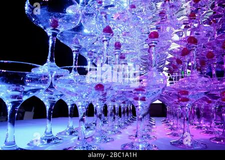 Auf dem Tisch steht ein Turm mit leeren Martini-Gläsern mit Kirsche. Party im Club Phaselis Rose Hotel in Kemer, Türkei, festlicher Abend in Tekirova Stockfoto