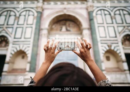 Nahaufnahme einer jungen Frau, die ein Smartphone-Foto in der Stadt Florenz, Italien, macht Stockfoto