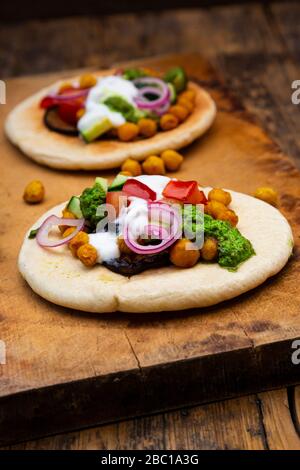 Israelischer Sabich mit Pita-Brot, Auberginen, Kichererbsen, Tomaten, Gurke, Joghurt und Zhoug-Sauce Stockfoto