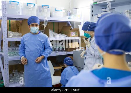 (200402) -- WUHAN, 2. April 2020 (Xinhua) -- Yuan Weifang (1. L), ein erfahrener Krankenpfleger der Intensivstation aus dem siebten Krankenhaus von Shanghai, nimmt eine Antibiotika-Injektion vor der Arbeit im Krankenhaus Leishenshan (Thunder God Mountain) in Wuhan, der zentralchinesischen Provinz Hubei, 20. März 2020. Yuan war einer der ersten medizinischen Mitarbeiter, die sich beworben hatten, um dem vom Virus heimgeplappten Wuhan City bei Ausbruch des COVID-19 zu helfen, obwohl er an einer Appendizitis litt und zu diesem Zeitpunkt eine Operation brauchte. Schließlich wurde er nach der zweiten Bewerbung als Mitglied der achten Runde des medizinischen Teams fr zur Ausreise nach Wuhan zugelassen Stockfoto