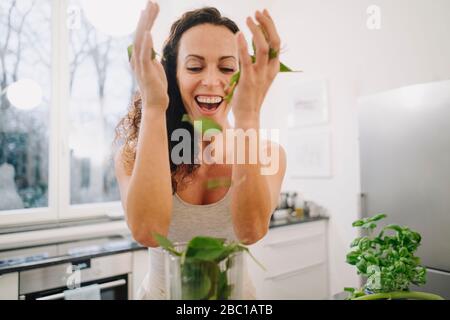 Fit Frau steht in der Küche, bereitet gesunde Smoothie, Putting Zutaten in Mixer Stockfoto