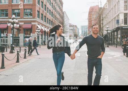 Ein glückliches Paar, das eine Straße in Vancouver, Kanada, entlang ging Stockfoto