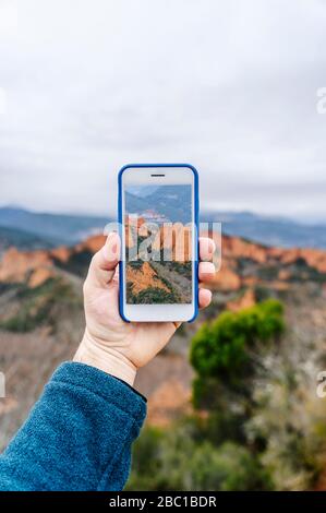 Mann mit Smartphone mit Bild von Mina de Oro Romana, Las Medulas, Kastilien und Leon, Spanien Stockfoto