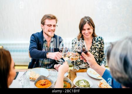 Freunde essen in einem indischen Restaurant, toasten Weingläser Stockfoto