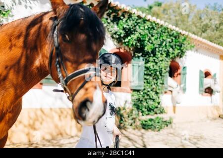 Teenager mit Down-Syndrom kümmert sich um Pferd und Vorbereitung Pferd zu reiten Stockfoto