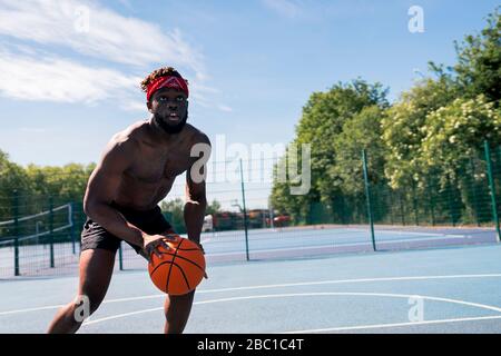 Mann, der Basketball spielt und nach oben schaut Stockfoto