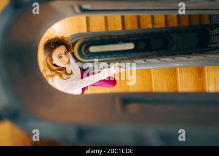 Porträt einer jungen Frau im Treppenhaus, die nach oben schaut Stockfoto