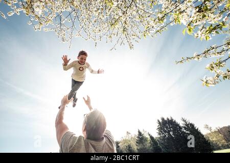 Vater warf Sohn in Luft Stockfoto