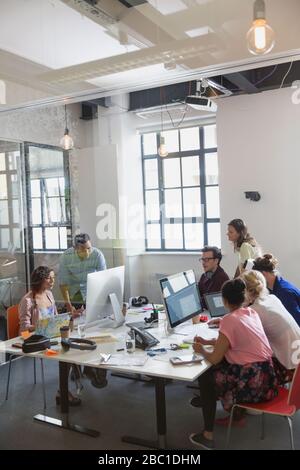 Designer treffen sich, arbeiten an Computern und Laptops im offenen Büro Stockfoto