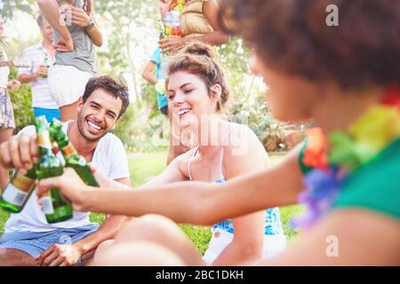 Junge Freunde hängen aus und toben Bierflaschen im Sommerpark Stockfoto