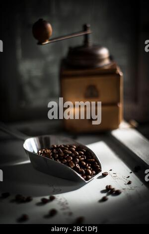 Schaufel gerösteten Kaffeebohnen mit Kaffeemühle im Hintergrund Stockfoto