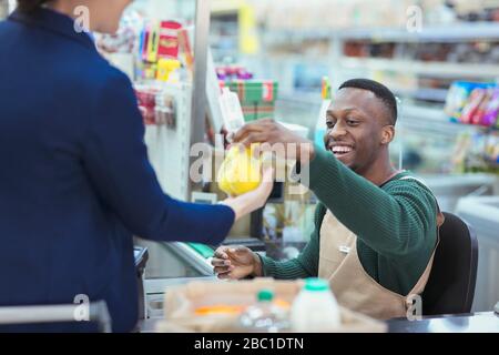 Kassierer hilft Kunden beim Supermarkt-Checkout Stockfoto