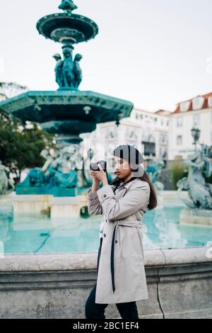 Junge Reisende mit Kamera am Brunnen des Rossio-Platzes, Lissabon, Portugal Stockfoto