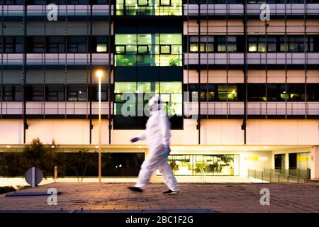 Wissenschaftlerin mit Schutzanzug und Maske vor einem Labor Stockfoto