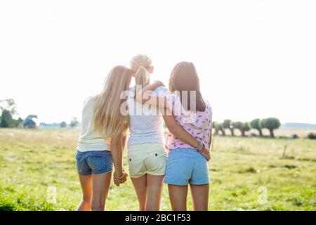 Rückansicht von liebevollen Mädchen auf einem Feld Stockfoto