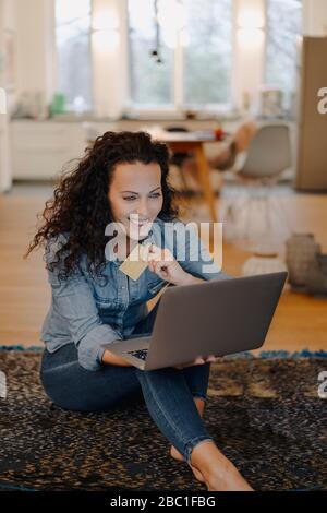 Frau, die eine Online-Zahlung mit Kreditkarte, mit Laptop Stockfoto