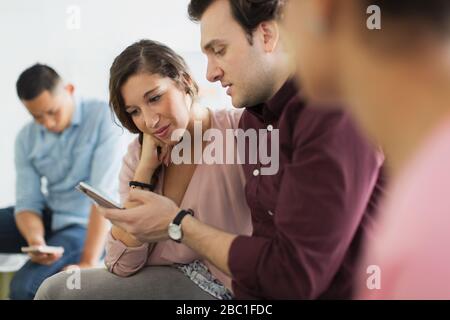 Geschäftsmann, der Geschäftsfrau ein digitales Tablet bei der Besprechung vorzeigt Stockfoto