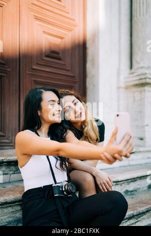Porträt von zwei Freunden auf Treppen sitzen Selfie mit Smartphone, Lissabon, Portugal Stockfoto