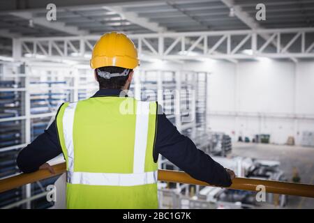 Männliche Führungskraft auf Plattform im Werk Stockfoto