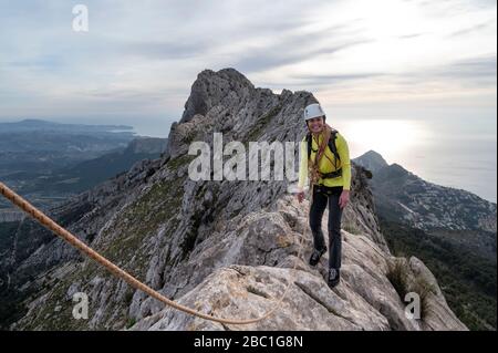 Lächelnde Frau Bergsteigen an Bernia Ridge, Costa Blanca, Alicante, Spanien Stockfoto