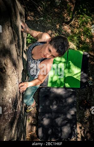 Klettersteigerin Bouldern auf Felsen, Avegno, Tessin, Schweiz Stockfoto