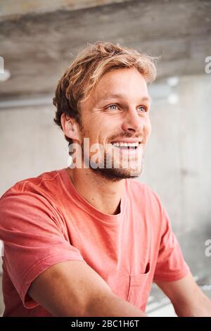 Porträt eines lachenden jungen Mannes mit rotem T-Shirt Stockfoto