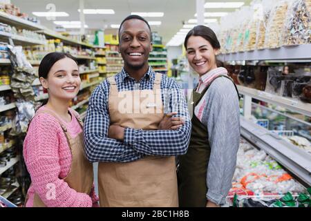 Portrait selbstbewusste, lächelnde Lebensmittelhändler, die im Supermarkt arbeiten Stockfoto