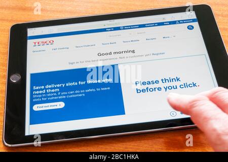 Die Tesco-Website während der Pandemie von Covid-19 Coronavirus bittet die Menschen zu denken, bevor Sie klicken, um Lieferfristen für wichtige Mitarbeiter und andere, die sie benötigen, zu sparen Stockfoto