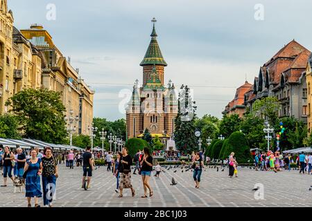 Die Menschen genießen den Siegesplatz und die Gärten vor der farbenfrohen orthodoxen Kathedrale in Temisoara, Rumänien. Juni 2017. Stockfoto