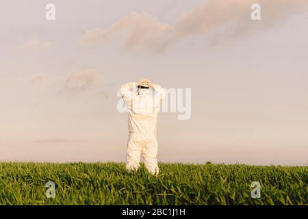 Rückansicht des Mannes mit Schutzanzug auf dem Land Stockfoto