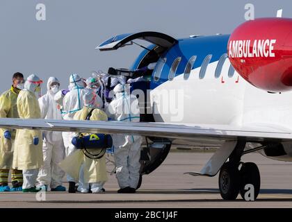 02. April 2020, Sachsen, Dresden: Ein schwer erkrankter Covid 19-Patient aus Frankreich wird von einem Ambulanzflugzeug zum Krankenwagen am Internationalen Flughafen Dresden transportiert. Das Flugzeug Learjet 45 kam aus Metzger und landete am Nachmittag auf dem Flughafen Dresden. Wie das Universitätsklinikum Dresden auf Anfrage mitteilte, sollen am Abend zwei weitere französische Patienten eintreffen. Das Fachkrankenhaus Coswig, das Krankenhaus Dresden-Friedrichstadt und das örtliche Universitätsklinikum versorgen jeweils einen der Patienten. Über ihre Identität ist nichts bekannt geworden. Sachsen hatte bereits acht zugelassen Stockfoto