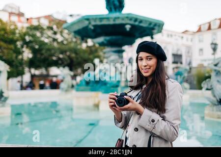 Junge Reisende mit Kamera am Brunnen des Rossio-Platzes, Lissabon, Portugal Stockfoto