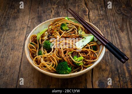 Schüssel mit japanischen Soba-Nudeln mit Bok Choy, Brokkolies, Sojasoße und schwarzem Sesam Stockfoto