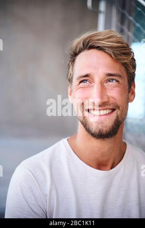 Porträt von lächelnden jungen Mann mit weißem t-shirt Stockfoto