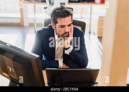 Frustriert Geschäftsmann am Schreibtisch im Büro Stockfoto