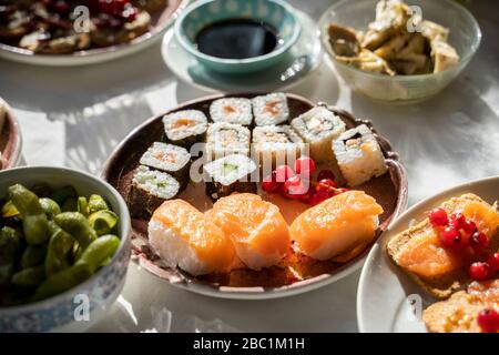 Spanien: Teller mit Sushi zum Essen auf einem gedeckten Esstisch Stockfoto