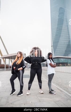 Drei sportliche junge Frauen posieren in der Stadt Stockfoto