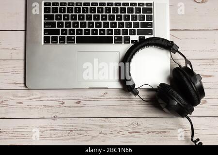 Notebook Mockup und Büro rustikaler Holzschreibtisch mit Notizbuch, Kopfhörer und Werk. Minimalistisches Design mit Stehkragenmuster und Draufsicht. Stockfoto