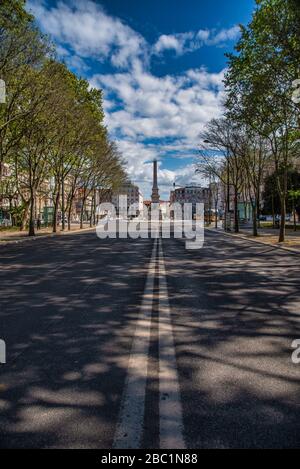 Seltene Aussicht auf die Avenida da Liberdade in Lissabon ohne Verkehr oder Fußgänger, mit dem zentralen Denkmal und dem baumgesäumten Boulevard. Stockfoto