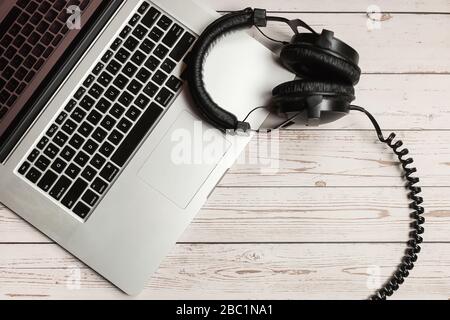 Notebook Mockup und Büro rustikaler Holzschreibtisch mit Notizbuch, Kopfhörer und Werk. Minimalistisches Design mit Stehkragenmuster und Draufsicht. Stockfoto