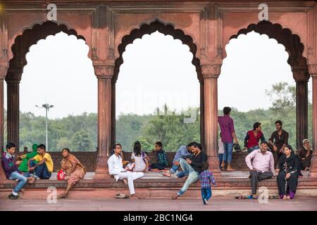 Einheimische, die sich unter architektonischen Bögen in der Jama Masjid Moschee in Old Delhi, Indien entspannen Stockfoto