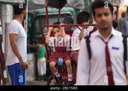 Porträt eines Schulkindes auf einer Rad-Rikscha in Delhi, Indien Stockfoto