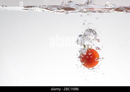 Frische rote Tomaten in Spritzer Wasser Stockfoto