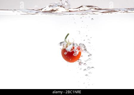 Frische rote Tomaten in Spritzer Wasser Stockfoto